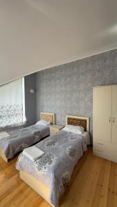 a bedroom with two beds and a wall at Peak Paradise Gabala Villa in Gabala