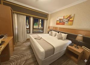 Una habitación de hotel con una cama grande y una ventana. en Golden Tulip Al Shakreen, en Medina