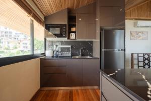 a kitchen with brown cabinets and a refrigerator at Club Bamboo Boutique Patong Beach Resort in Patong Beach