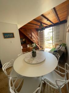 a dining room with a white table and chairs at Apartamento Pé na Areia- Torres in Torres +10 photos