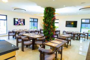 a restaurant with tables and chairs and a green wall at King Georges Court in Mama