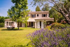 a house with purple flowers in the yard at Auberge De Saint-Rémy - Hôtel & Villa - Restaurant Gastronomique 2 Étoiles in Saint-Rémy-de-Provence