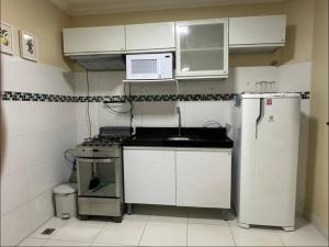 a small kitchen with a sink and a refrigerator at Apartamento para 4 hóspedes COP30 Prox Hangar e Mangueirão 1 garagem condominio portaria 24h in Belém