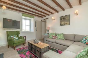 Una sala de estar con un sofá y un televisor. en Erw-Dinmael, en Cerrig-y-Druidion