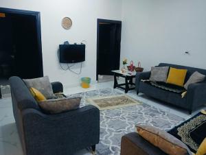 a living room with two couches and a tv at مجموعة سوما الفندقية in Al Madinah