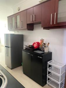 a kitchen with brown cabinets and a black dishwasher at Time and Spenser Apartment ,condo in Wellawatta