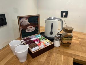 a table topped with a coffee maker and a box of food at Apartament Baszta 7 Płaszczy, Panieńska in Szczecin