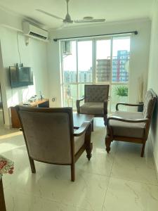 a living room with two chairs and a coffee table at Time and Spenser Apartment ,condo in Wellawatta