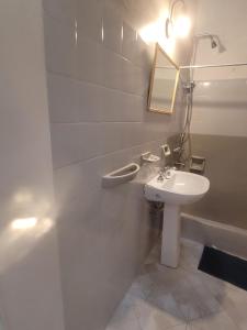 a white bathroom with a sink and a mirror at El departamento de las flores in Gualeguaychú