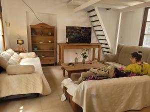 a woman sitting on a couch in a living room at El departamento de las flores in Gualeguaychú