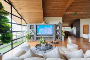 パトンビーチにあるClub Bamboo Boutique Patong Beach Resortのリビングルーム(大型テレビ、白い家具付)