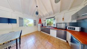 a large kitchen with blue and white cabinets and counters at LocationTiBalisier pointe sud Martinique in Sainte-Anne