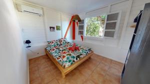 a bedroom with a bed in a room with a window at LocationTiBalisier pointe sud Martinique in Sainte-Anne