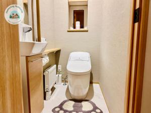 a small bathroom with a toilet and a sink at Snow Sapporo Homestay in Sapporo +13 photos