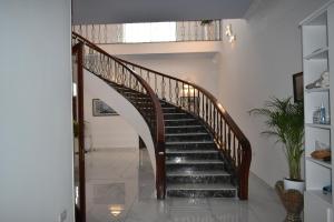 a staircase with a wooden rail in a house at Villa Lu Bartolo - Room Rose in Taʼ Lampuka +1 photo