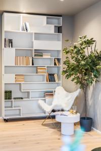 a living room with a book shelf and a chair at Two bedroom penthouse with large living room and rooftop in the city centre of Trondheim in Trondheim