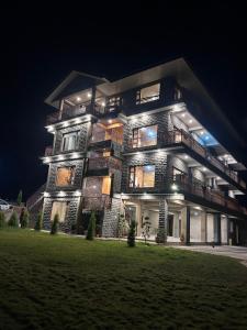 a large building with lights on it at night at Shalom Hillcrest Inn in Shimla