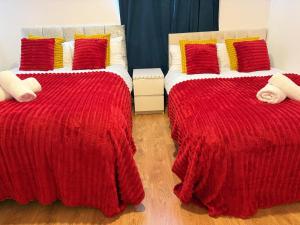 a bedroom with two beds with red and yellow pillows at 5 Brunswick - room 04 in Bristol
