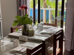 a table with a vase with a flower on it at Residencial Aeroporto in São Tomé