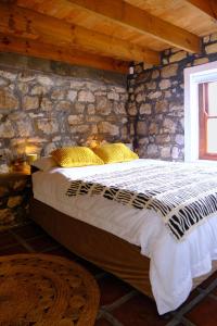 a bedroom with a bed in a stone wall at MM Good Times in Gansbaai