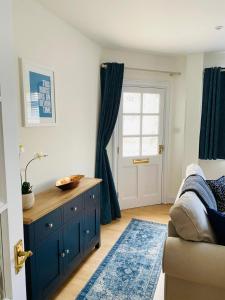 une chambre avec une commode bleue et une fenêtre dans l'établissement Beer Bakery Cottages - Charming Cottage Retreat - 2 mins from Beach with Car Parking space, à Beer