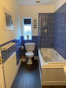 une salle de bain avec une baignoire, des toilettes et un lavabo dans l'établissement Beer Bakery Cottages - Charming Cottage Retreat - 2 mins from Beach with Car Parking space, à Beer