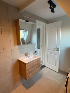a bathroom with a sink and a mirror and a door at Abcoude city center in Abcoude
