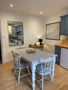 une cuisine avec une table et des chaises dans une pièce dans l'établissement Beer Bakery Cottages - Charming Cottage Retreat - 2 mins from Beach with Car Parking space, à Beer 18 autres photos
