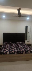 a bedroom with a bed with a flowered blanket on it at Arora golden guest house in Amritsar