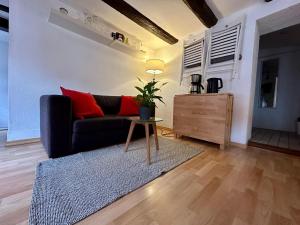 a living room with a black couch and a table at Baumeisterhaus Apartment in Bad Hersfeld
