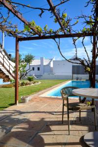 a table and a bench next to a swimming pool at MM Good Times in Gansbaai +21 photos