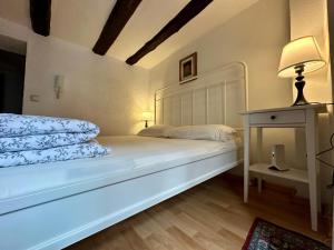 a bedroom with a white bed with a lamp and a table at Baumeisterhaus Apartment in Bad Hersfeld +4 photos