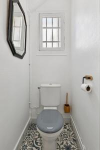 a bathroom with a toilet with a mirror and a window at Luxury Paris Apt, Metro 4 & RER B, 6 guests, CDG Access in Paris +12 photos