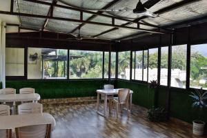 a restaurant with tables and chairs and windows at Pam Green in Mussoorie