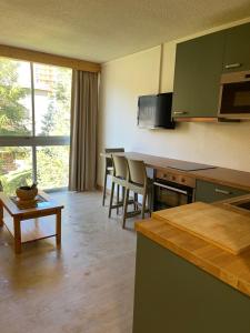 a kitchen with green cabinets and a table and chairs at Vallonpierre2 in Orcières
