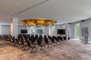 a conference room with rows of chairs and screens at Hotel Pestera Wellness & Spa in Sinaia +101 photos