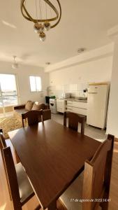 a kitchen and dining room with a table and a refrigerator at Apto em Barretos Próximo PIO XII in Barretos