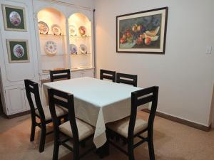 a dining room with a white table and chairs at La casita del abu Alfredo in Cochabamba +11 photos