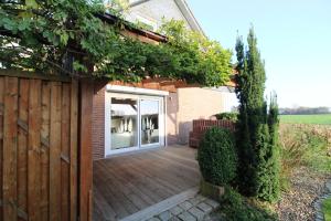 a wooden deck with a sliding glass door at Küstenkind in Spieka-Neufeld