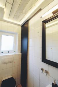 a bathroom with a toilet and a window and a mirror at Küstenkind in Spieka-Neufeld +13 photos