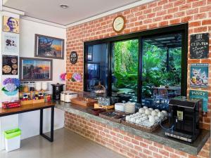 a restaurant with a brick wall with a food counter at Ideo Phuket Hotel - Naiyang Beach in Nai Yang Beach