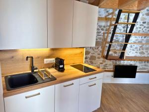 a kitchen with white cabinets and a sink at Cocon - Hyper Centre - Clim - Wifi in Dax
