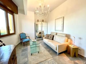 a living room with a couch and a chandelier at Hostdomus - La Rocca in Garlenda