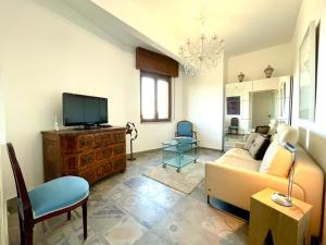 a living room with a couch and a tv at Hostdomus - La Rocca in Garlenda