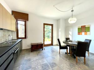 a kitchen and dining room with a table and chairs at Hostdomus - La Rocca in Garlenda