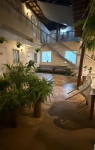 a lobby of a building with plants and a staircase at Pousada Mel in Praia do Forte