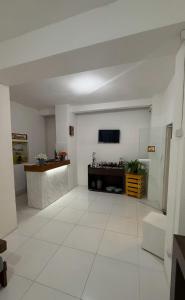 a large white room with a tv on the wall at Pousada Mel in Praia do Forte