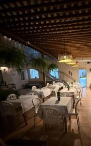 a restaurant with white tables and chairs in a building at Pousada Mel in Praia do Forte