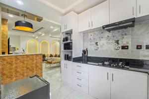 a kitchen with white cabinets and black counter tops at The Champagne Suite in Mama