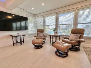 Una sala de espera con sillas, mesas y ventanas. en Penthouse Shores 309, en Clearwater Beach